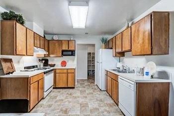 a kitchen with white appliances and wooden cabinets